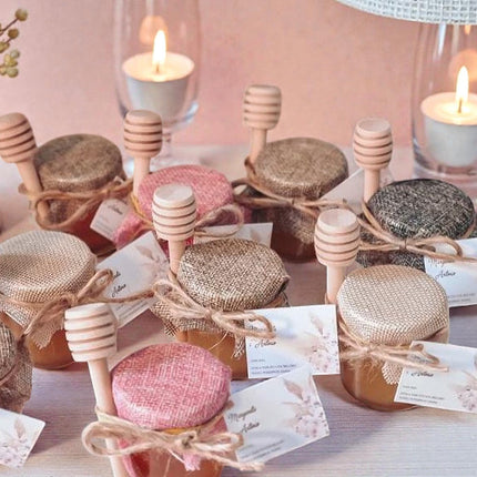 Small jars with honeycomb lids on a table with candles and decorative items.
